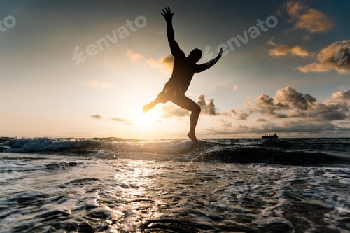 Preview: Silhouette of man jumping on beach.