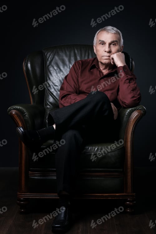 Preview: Portrait of serious senior man in armchair