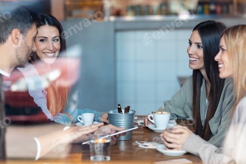 Preview: happy friends group eating burgers while talking about work sitting in restaurant.
