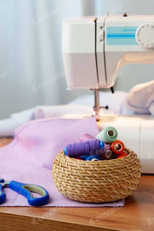 Preview: Sewing machine in use on a wooden table, stitching a light fabric in a well-lit indoor workspace