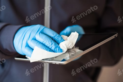 Preview: man hands in gloves disinfecting tablet computer screen, eliminate germs coronavirus bacteria