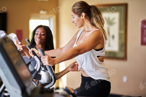 Preview: personal trainer helping woman use treadmill in gym