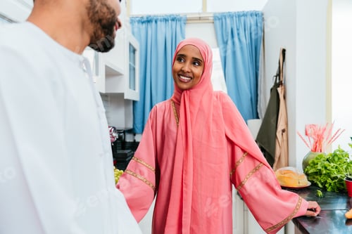 Preview: Happy middle eastern couple wearing traditional arab clothing at home