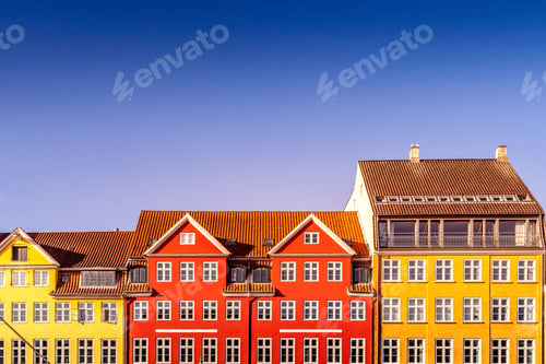Preview: beautiful colorful historical houses against blue sky in copenhagen, denmark