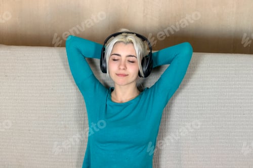 Preview: Young woman closed eye and enjoying the music and relax sit at home, asian beauty