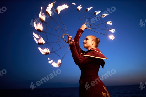 Preview: Woman dancing with fire against night sky