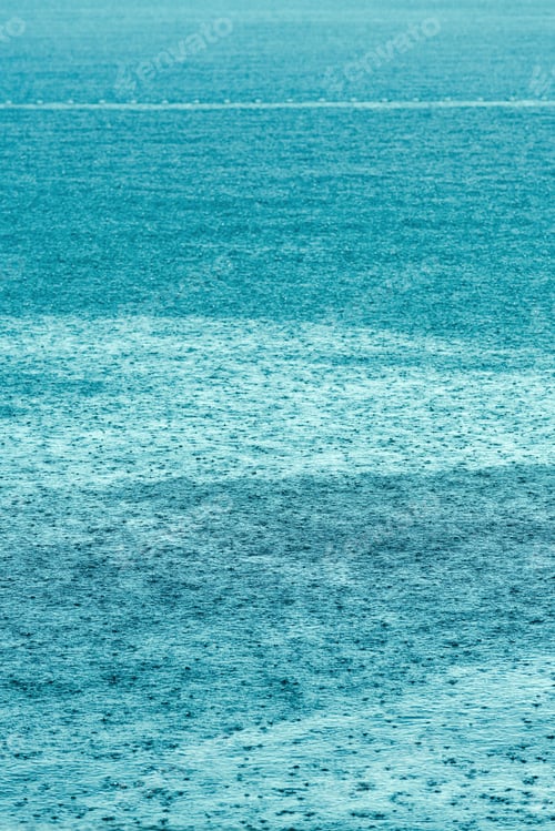 Preview: Sudden summer shower rain at seaside, raindrops forming patterns on water surface