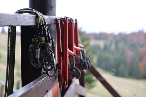 Preview: large metal locking carabiners with rope, climbing gear hanging on the store room