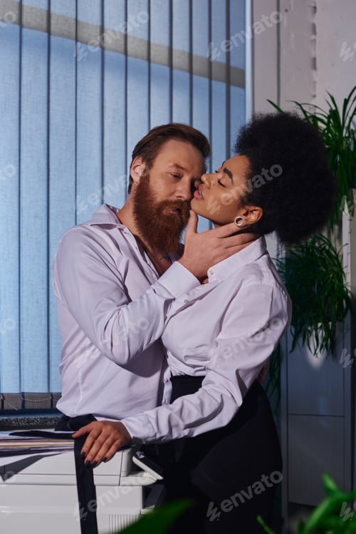 Preview: bearded tattooed businessman hugging neck of hot african american woman near copier in office