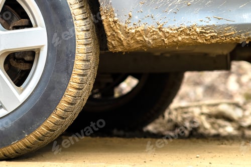 Preview: Close up of dirty car wheel with rubber tire covered with yellow mud