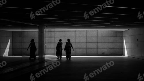 Preview: Silhouette of women walking in a dark station with minimal light