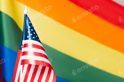 Preview: close up of american flag with blurred lgbt colors on background, equality rights concept