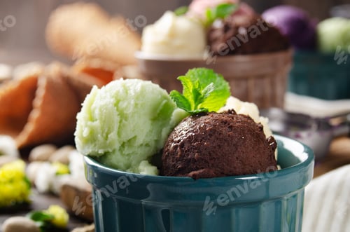 Preview: Three scoops of Vanilla pistachio and chocolate icecream balls in clay bowls on wooden kitchen table