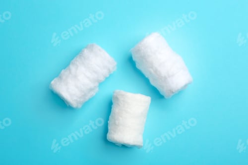 Preview: Three fluffy cotton rolls on color background, flat lay