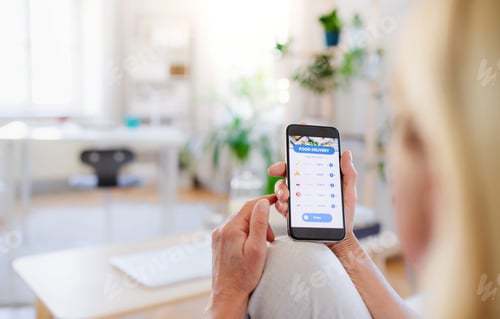 Preview: Unrecognizable woman with smartphone indoors at home, ordering food