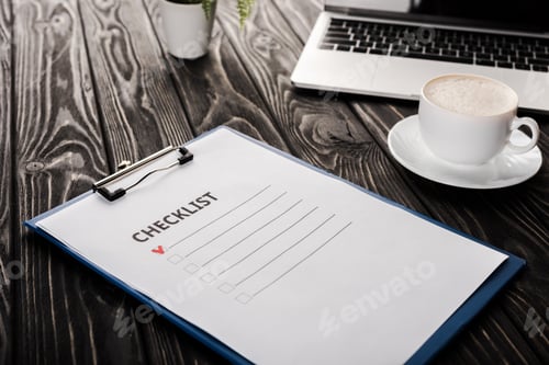 Preview: selective focus of clipboard with checklist near laptop and cup of coffee on table, e-commerce