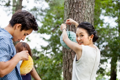 Preview: Two people hanging lanterns for a party.