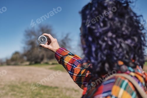 Preview: Woman hiking using compass for navigation outdoors