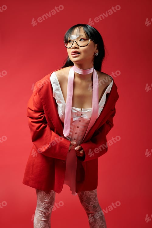 Preview: The beautiful Asian woman poses gracefully in a chic red outfit, exuding confidence and style