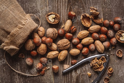 Preview: flat lay with nuts, nutcracker and sack on wooden tabletop