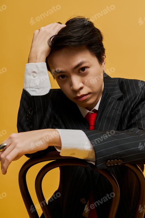 Preview: Elegant young businessman posing confidently in a stylish suit with a vibrant background