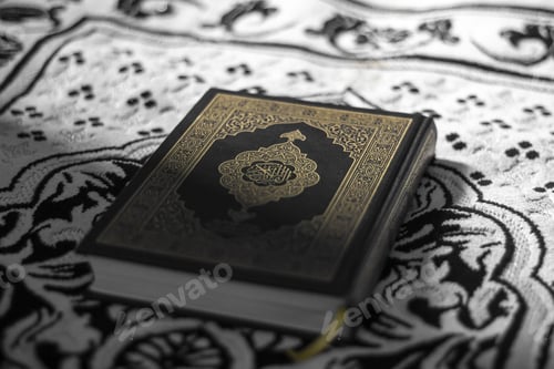 Preview: Closeup of a Quran with intricate book cover design, on a rug