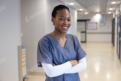 Preview: Portrait of happy african american female doctor in hospital corridor