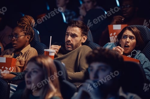 Preview: Group of friends watching scary movie at the cinema.