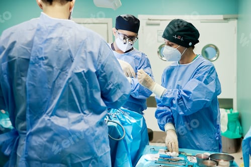 Preview: Unrecognizable surgeon with assistants during operation in clinic