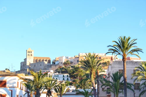 Preview: Ibiza old town skyline in summer. Holiday destination with blue sky and palm trees