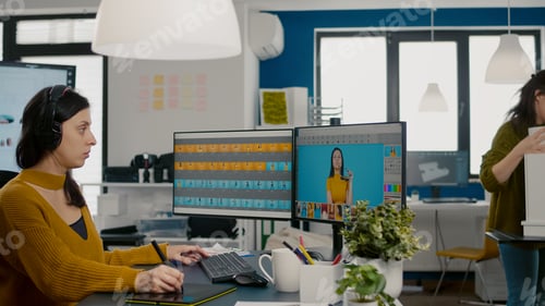 Preview: Focused retoucher specialist working at computer in creative office