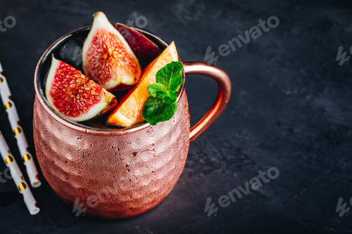 Preview: Fig moscow mule ice cold cocktail in copper cup with oranges and mint