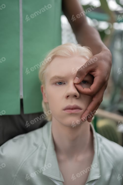 Preview: Close up of African American man touching face of blonde man