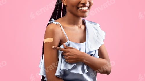 Preview: Cropped view of young black lady pointing at adhesive plaster om her arm after coronavirus