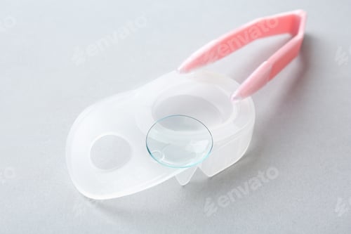 Preview: Package with contact lens and tweezers on light background