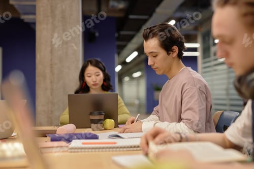 Preview: Concentrated Male Student Completing Assignment on Seminar Session