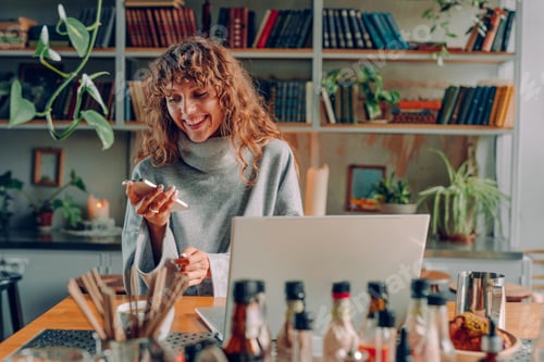 Preview: Smiling young woman freelancer working at the vintage cafe using smartphone