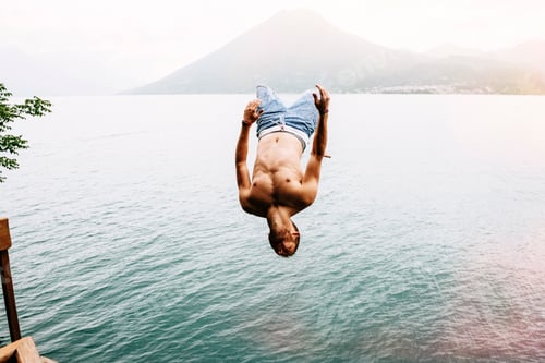 Preview: Man midair diving into a serene lake against a mountain backdrop