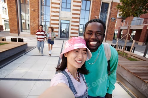 Visualização: Estudantes tirando uma foto de selfie juntos no campus da faculdade e sorrindo para a câmera