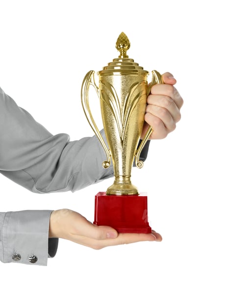 Preview: Woman with golden trophy cup on white background, closeup