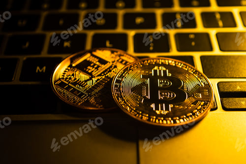 Preview: Golden coins with bitcoin symbol on computer.