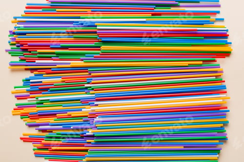 Preview: many multi-colored plastic tubes for cocktail on Colored background, top view
