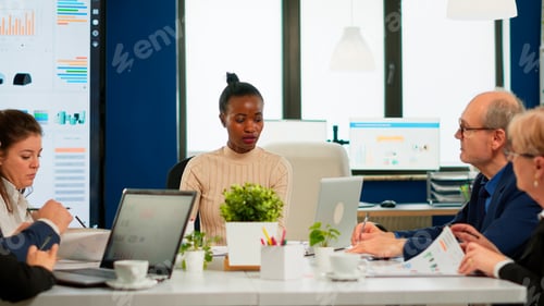 Preview: Ethnic executive management planning business plan sitting in boardroom