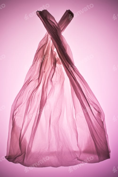 Vista previa: bolsa de plástico transparente arrugada bajo una luz de tono rosa