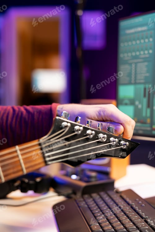 Preview: Skilled musician tuning his acoustic guitar strings to record new audio files