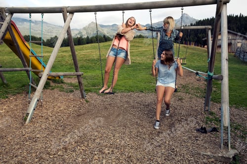 Preview: Three female adult friends playing on swings in Austrian Alps, Sattelbergalm, Tirol, Austria
