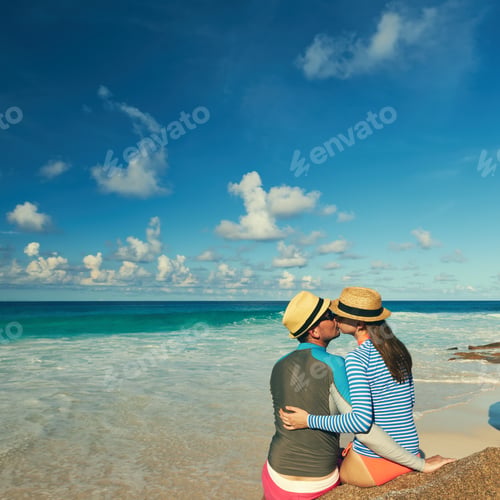 Preview: Couple On A Tropical Beach At Seychelles Wearing Rash Guard