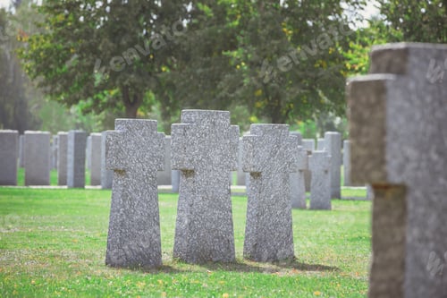 Preview: selective focus of identical old gravestones placed in row on grass at cemetery