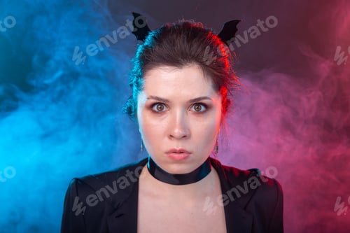 Preview: Halloween, holidays and carnival concept - vamp woman in jacket and with bat ears in gothic style.