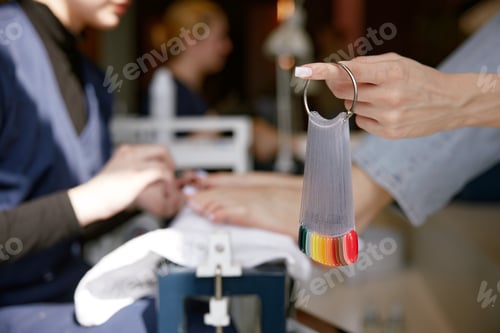 Preview: Closeup view on color palette with nail gel varnish for pedicure in client hand